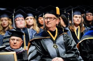 Dean Michael Lairmore listens to a speaker at this year's commencement ceremony.