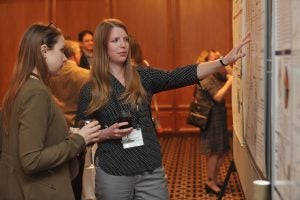 Hannah Laurence (on right) explains her research at the American Society of Clinical Investigators (ASCI) Joint Meeting in Chicago, Illinois. Photo credit: Randy Belice for the Howard Hughes Medical Institute